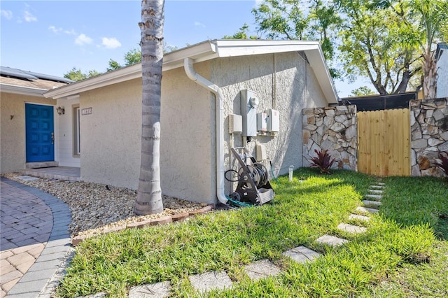 view of side of home with fence and stucco siding