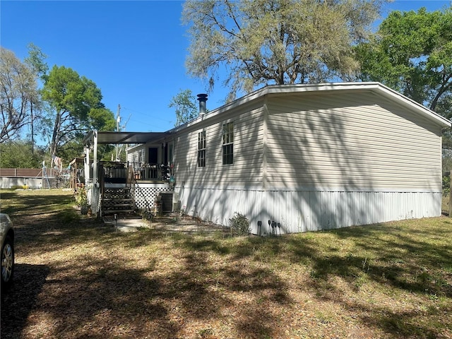 view of home's exterior featuring central air condition unit, a lawn, and a wooden deck