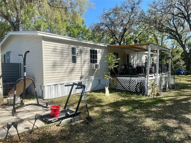 rear view of house with a wooden deck and a yard