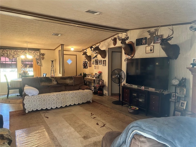 living room with a notable chandelier, wood finished floors, and a textured ceiling