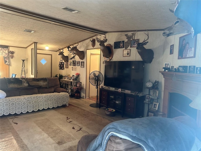 living area featuring visible vents, a textured ceiling, and vaulted ceiling with beams