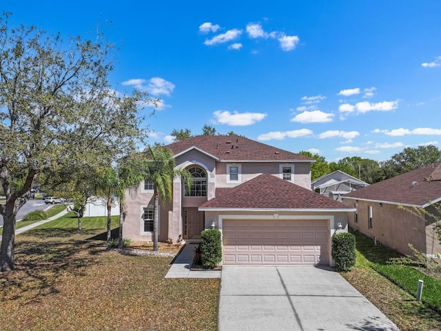 traditional-style house featuring stucco siding, an attached garage, concrete driveway, and a front lawn