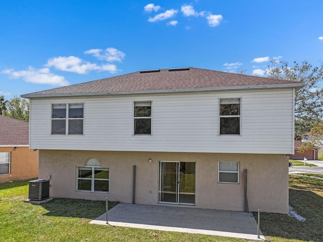 back of property with central air condition unit, a lawn, a patio area, and stucco siding