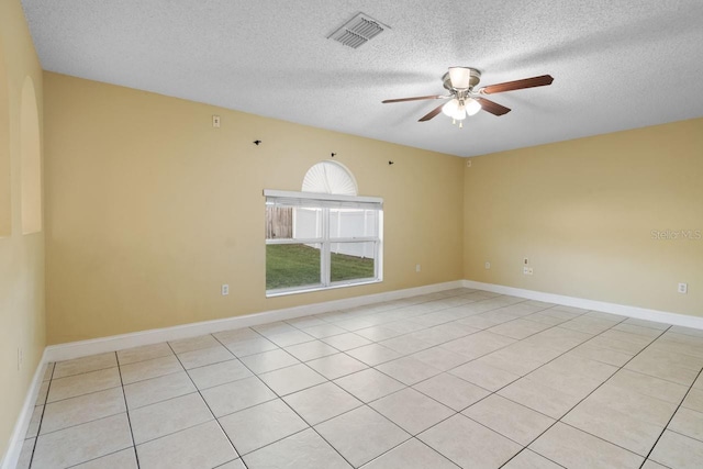 empty room featuring a textured ceiling, baseboards, visible vents, and ceiling fan