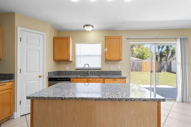 kitchen with a sink, a center island, dark stone countertops, light tile patterned flooring, and stainless steel dishwasher