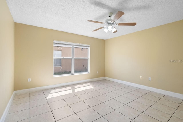 unfurnished room featuring light tile patterned flooring, a textured ceiling, baseboards, and ceiling fan