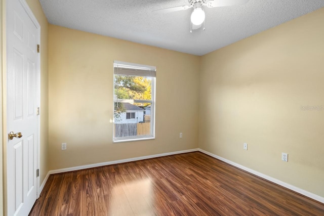 spare room featuring baseboards, a textured ceiling, ceiling fan, and wood finished floors