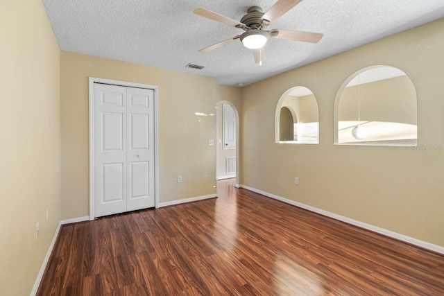 unfurnished bedroom featuring wood finished floors, visible vents, a closet, and a textured ceiling