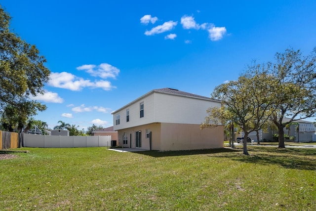 back of house featuring a patio area, a yard, fence, and stucco siding