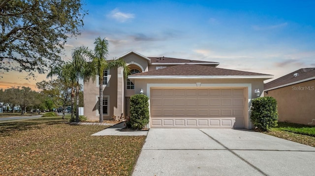 view of front of home featuring a garage, driveway, and stucco siding