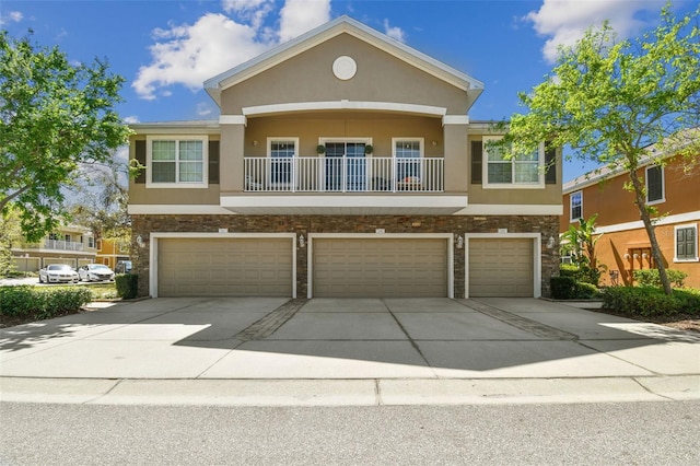 view of front of property with stone siding, stucco siding, driveway, and an attached garage