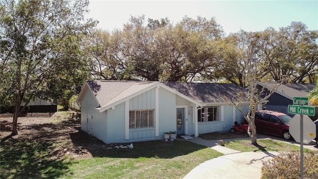 view of front of property with a garage, a shingled roof, and a front yard