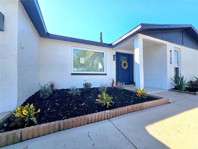 doorway to property featuring stucco siding