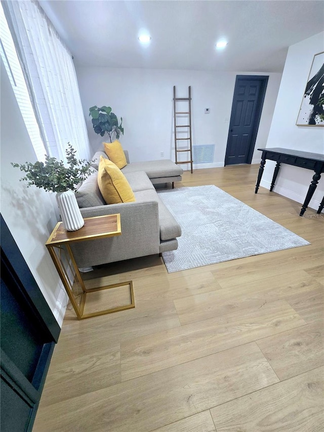 living room with recessed lighting, baseboards, and wood finished floors