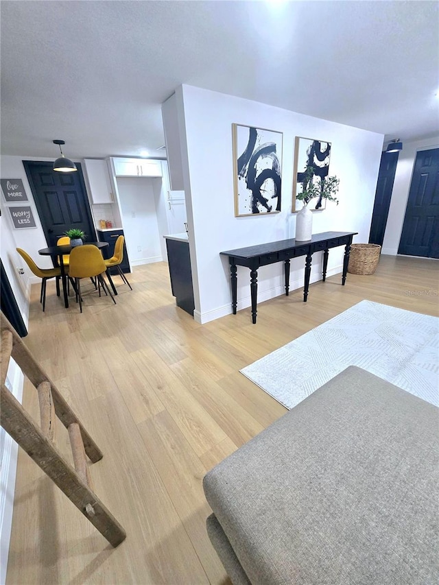 living area with light wood-type flooring and baseboards