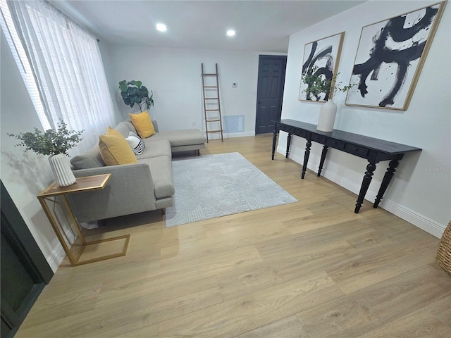 living area with recessed lighting, light wood-type flooring, baseboards, and visible vents