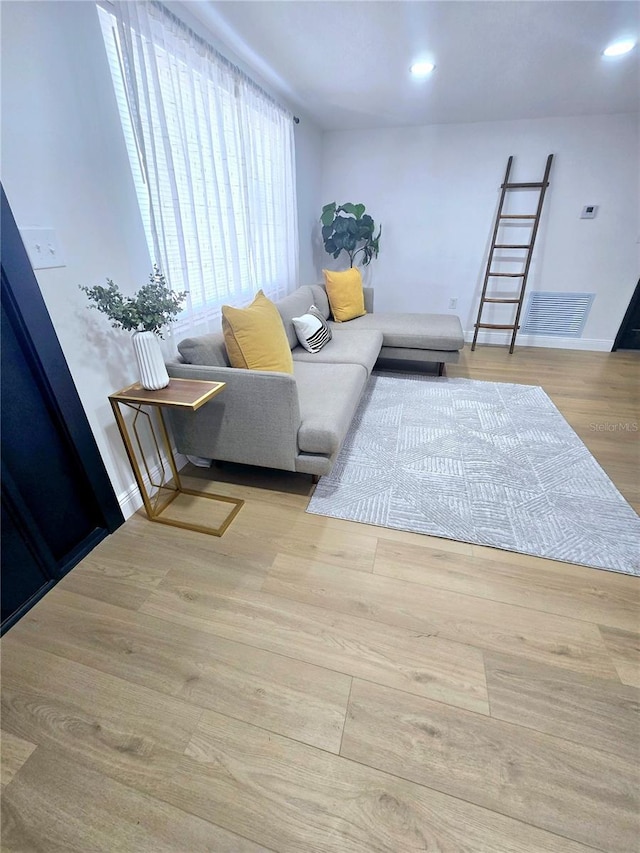 living area with recessed lighting, baseboards, and wood finished floors