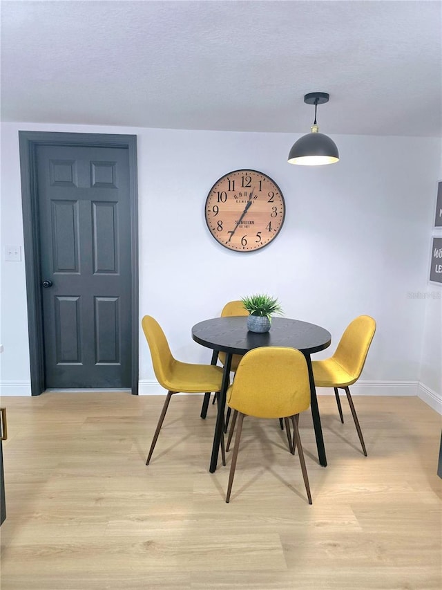 dining room featuring baseboards and light wood finished floors