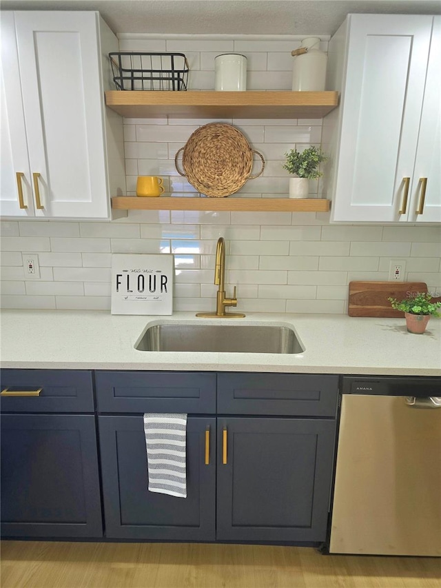 kitchen featuring a sink, dishwasher, white cabinetry, and open shelves