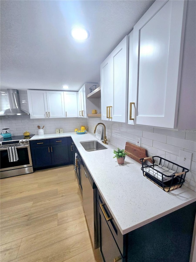 kitchen featuring a sink, open shelves, white cabinetry, stainless steel appliances, and wall chimney exhaust hood