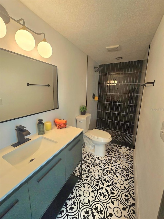 full bathroom featuring visible vents, tiled shower, tile patterned flooring, a textured ceiling, and toilet