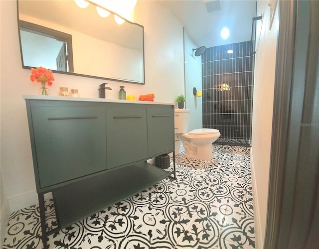 bathroom featuring tile patterned flooring, visible vents, toilet, a tile shower, and vanity