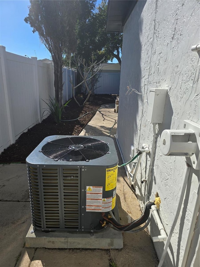 exterior details featuring central air condition unit, a fenced backyard, and stucco siding