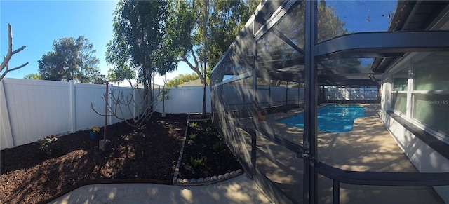 view of pool with a fenced in pool, a patio, a fenced backyard, and glass enclosure