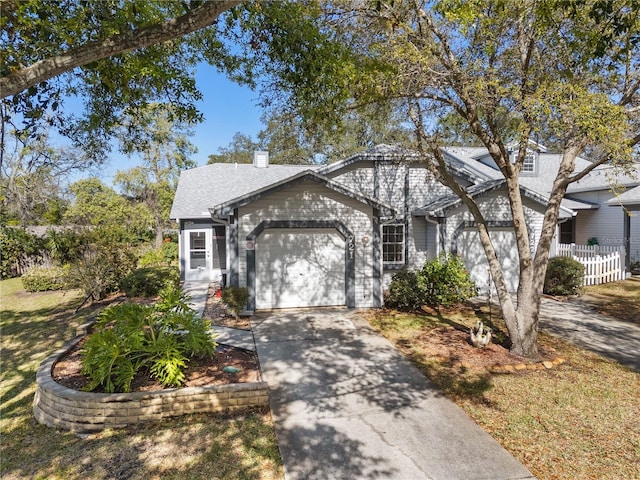 view of front of property featuring an attached garage, a chimney, driveway, and a shingled roof