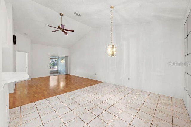 unfurnished room with vaulted ceiling, light wood-style flooring, ceiling fan with notable chandelier, and visible vents