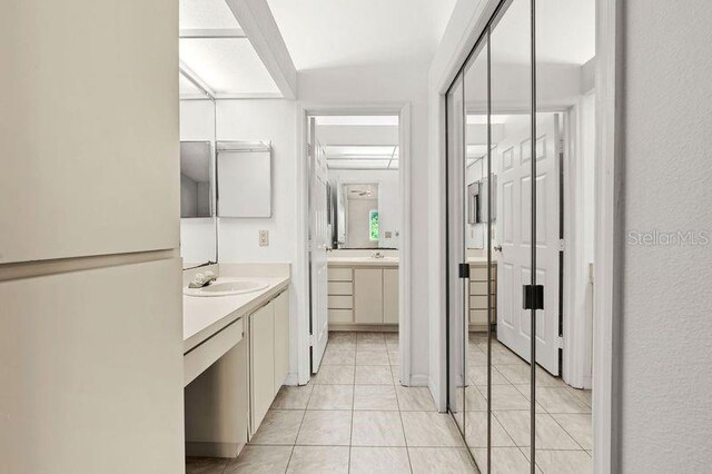 bathroom featuring tile patterned floors, two vanities, and a sink