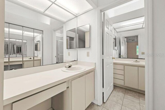 bathroom featuring a sink, two vanities, and tile patterned flooring