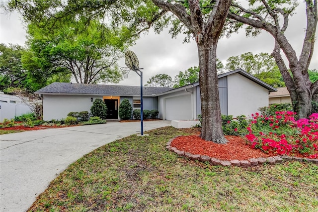 view of front of property with stucco siding, an attached garage, and concrete driveway