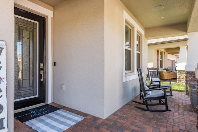 entrance to property featuring stucco siding and a porch