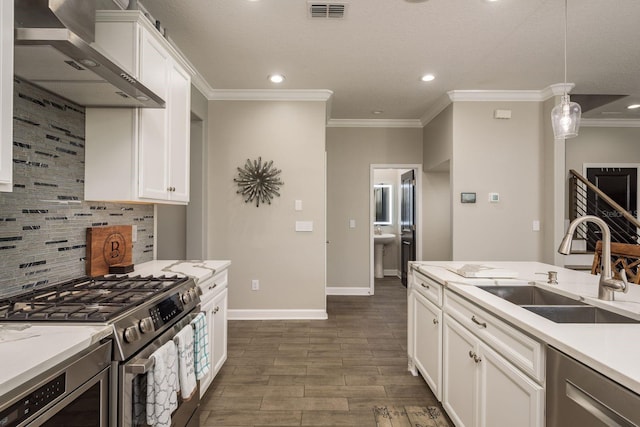 kitchen with tasteful backsplash, visible vents, wall chimney range hood, appliances with stainless steel finishes, and a sink