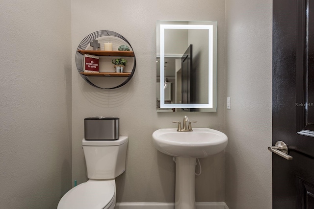 bathroom with toilet and a sink