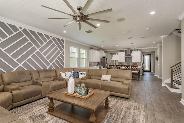 living area featuring visible vents, dark wood finished floors, recessed lighting, stairs, and crown molding