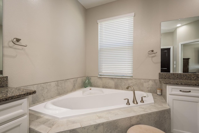 full bathroom featuring a bath and vanity