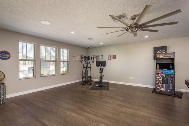 exercise area featuring dark wood finished floors, visible vents, and baseboards