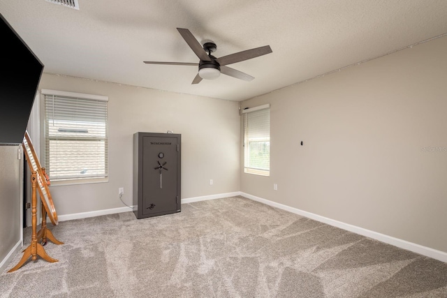 interior space featuring carpet, a healthy amount of sunlight, baseboards, and a ceiling fan