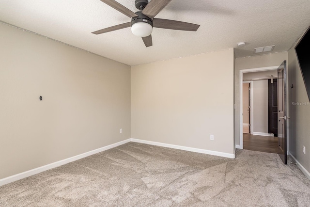 unfurnished bedroom featuring carpet flooring, ceiling fan, a textured ceiling, and baseboards