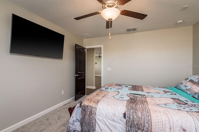 carpeted bedroom with visible vents, a textured ceiling, baseboards, and a ceiling fan