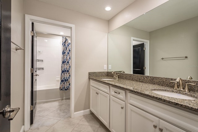 full bathroom with double vanity, shower / bathtub combination with curtain, tile patterned floors, and a sink