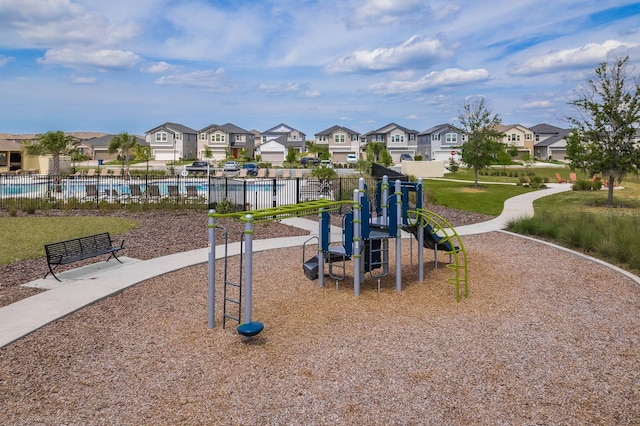 community jungle gym featuring a residential view, a community pool, and fence