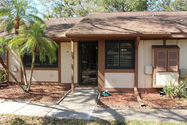 property entrance featuring roof with shingles