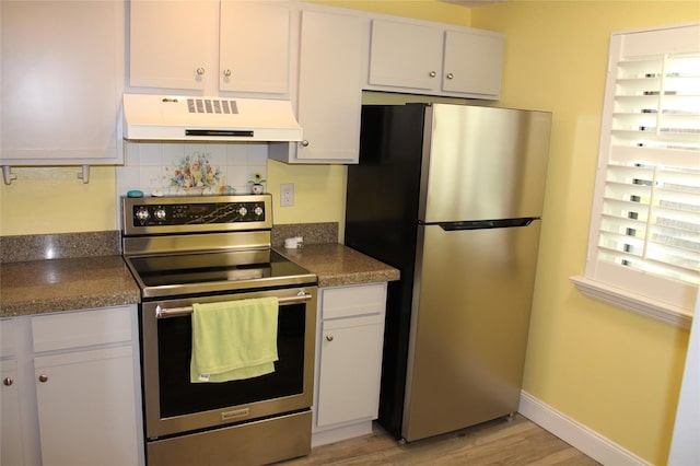 kitchen with under cabinet range hood, backsplash, light wood-style floors, appliances with stainless steel finishes, and white cabinets