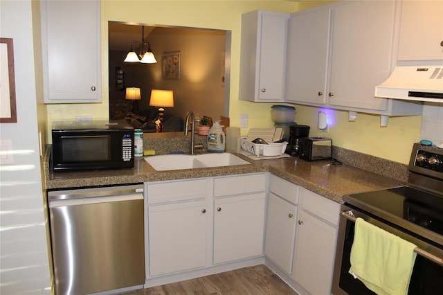 kitchen with light wood-type flooring, a sink, appliances with stainless steel finishes, white cabinets, and extractor fan