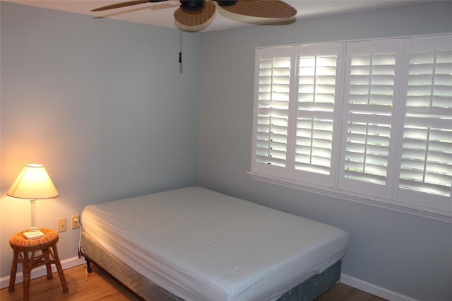 bedroom featuring baseboards and wood finished floors