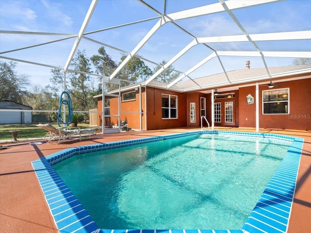 outdoor pool featuring glass enclosure, a patio, a ceiling fan, and french doors