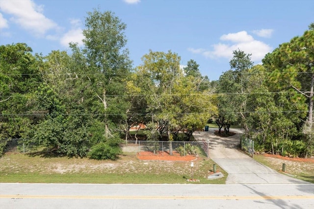 view of community with concrete driveway and fence